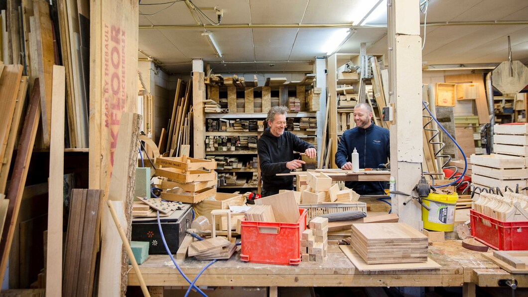 Twee mensen in een werkplaats, waar producten met hout worden gemaakt